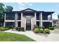 Two-story condo building with screened porches, lush landscaping, and well-maintained grounds at 4015 Angel Oak Ct # 201, Tampa, FL 33613