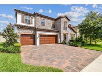 Stunning two-story home boasts stone accents, a three-car garage, and a brick paved driveway at 4083 Woods Rider Loop, Odessa, FL 33556