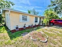 Charming single-story home featuring well-maintained landscaping and a red car in the driveway at 4628 Irene Loop, New Port Richey, FL 34652