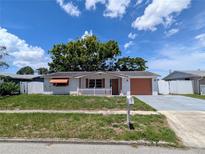 Quaint single story home with a white picket fence, charming details, and well-kept landscaping at 4853 Alcea St, New Port Richey, FL 34652