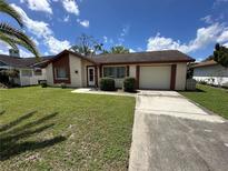 Charming single-story home featuring a well-manicured lawn and attached garage at 8312 Split Rail Ln, Hudson, FL 34667