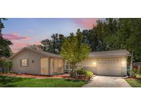 Charming single-story home with a well-manicured lawn, cozy screened porch, and attached two-car garage at 8404 Fishhawk Ave, New Port Richey, FL 34653