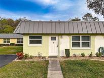 Inviting single-story home featuring a quaint, well-manicured front yard and a charming, light-colored exterior at 11722 Carissa Ln # 49A, New Port Richey, FL 34654