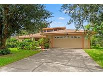 Charming home features a two-car garage and meticulously maintained landscaping and a long driveway at 23302 Lucerne Pl, Land O Lakes, FL 34639
