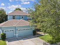 Charming two-story home with a three car garage and nicely landscaped front yard at 4481 Birchfield Loop, Spring Hill, FL 34609