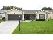 Charming one-story home with a well-manicured lawn, stone accents, and a spacious driveway leading to a two-car garage at 4702 Portland Manor Dr, New Port Richey, FL 34655