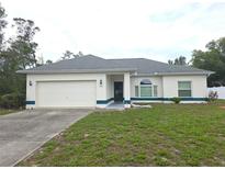 Charming single-story home featuring a two-car garage and tidy front yard with lawn at 5373 Frost Rd, Spring Hill, FL 34606