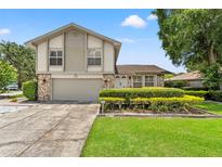 Charming two-story home with landscaped yard and two-car garage under a sunny blue sky at 5502 Bluejay Ln, Tampa, FL 33625