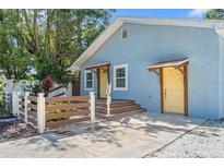 Charming light blue single-story home with a bright yellow door and inviting wooden porch steps at 5724 Casson Ave, New Port Richey, FL 34652