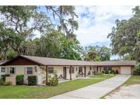 Charming multi-Gathering home featuring lush landscaping, mature trees, and covered front patios at 6019 Wyoming Ave, New Port Richey, FL 34653