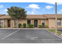 Charming condo featuring stone accents, mature landscaping, and assigned parking at 7122 Barclay Ave # B, Spring Hill, FL 34609