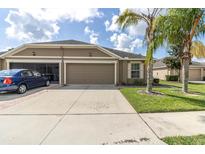 Charming, single-story home featuring a 2-car garage, manicured lawn and attractive landscaping, perfect for suburban living at 13600 Crest Lake Dr, Hudson, FL 34669
