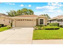 Charming single-story home featuring a two-car garage, landscaped lawn, and neutral-toned exterior at 15004 Middle Fairway Dr, Spring Hill, FL 34609