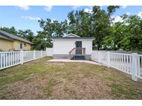 View of charming back house with a white picket fence and a small wooden porch under a cloudy blue sky at 4622 Paloverde Dr, New Port Richey, FL 34652