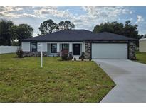 Beautiful single-story home with manicured lawn, two-car garage, stone accents and neutral paint at 5555 Baffin Cir, Spring Hill, FL 34606