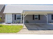 Charming single-story home featuring a covered carport, well-maintained landscaping, and neutral exterior paint at 6702 Dartmoor Ln # 7A, New Port Richey, FL 34653