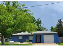 Charming blue one-story home featuring an attached garage and arched entry at 8504 Lafitte Dr, Hudson, FL 34667