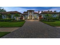 A stunning home featuring a paver driveway, manicured landscaping, and elegant design, perfect for luxurious living at 9704 Milano Dr, Trinity, FL 34655