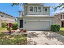 Charming two-story home with a two car garage and a well-maintained lawn and landscaped yard at 9706 Simeon Dr, Land O Lakes, FL 34638