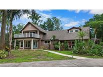 Charming two-story home featuring a welcoming front yard, upper deck, and lush landscaping at 2202 Amity Ct, New Port Richey, FL 34655