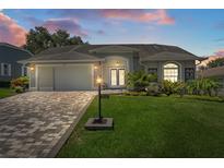 Charming single-story home featuring a paved driveway, lush lawn, and meticulously landscaped front yard at 2275 Terrace View Ln, Spring Hill, FL 34606