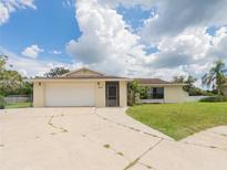 Charming single Gathering home with a well-maintained front yard and attached two-car garage at 2414 San Luis Rd, Holiday, FL 34691