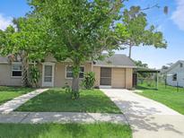 Charming single-story home with well-maintained lawn, covered parking, and mature landscaping at 6030 17Th St, Zephyrhills, FL 33542