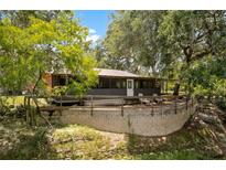 Charming home exterior with a spacious deck and scenic natural surroundings at 6410 Amelia Ln, Dade City, FL 33523