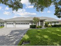 Charming one-story home boasts a well-manicured lawn and a spacious three-car garage at 6545 North Lake Dr, Zephyrhills, FL 33542