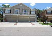 Charming townhome showcasing three garage doors and second-story balconies at 7650 Red Mill Cir, New Port Richey, FL 34653