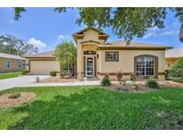 Inviting single-story home featuring a well-maintained lawn and colorful landscaping at 9406 Burnam Dr, Weeki Wachee, FL 34613