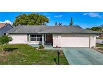 Charming single-story home featuring a well-maintained lawn, classic brick facade, and an attached two-car garage at 9425 Sterling Ln, Port Richey, FL 34668