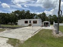Inviting single-story home with white siding, red shutters, and a spacious driveway for ample parking at 10654 Holgate St, New Port Richey, FL 34654