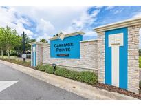 Attractive entrance sign for Carriage Pointe featuring manicured landscaping and a stacked stone and blue sign at 12119 Barnsley Reserve Pl, Gibsonton, FL 33534