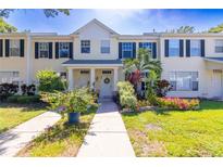 Charming townhome with a well-manicured lawn and colorful flower beds at 13651 Forest Lake Dr, Largo, FL 33771
