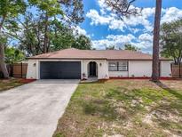 Charming single-story home featuring a well-manicured lawn and a two-car garage at 1652 Larkin Rd, Spring Hill, FL 34608