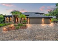 Stunning home featuring a three-car garage, stone accents, and lush landscaping at 26221 Pheasant Run, Wesley Chapel, FL 33544