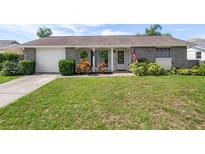 Charming single-story home with a lush green lawn and beautiful stone accents at 6930 El Camino Paloma St, Port Richey, FL 34668