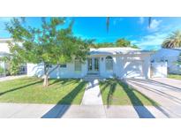 Charming single-story home featuring a lush green lawn, mature tree, and well-maintained landscaping at 750 Lantana Ave, Clearwater, FL 33767