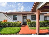 Charming single-story home with a well-manicured lawn and colorful walkway leading to the front door at 7715 Radcliffe Cir, Port Richey, FL 34668