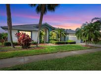 Charming single-story home with a lush green lawn and mature tropical landscaping, creating a welcoming curb appeal at 8540 Caitlin Ct, Hudson, FL 34667