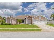 Charming single-story home with a well-manicured lawn, beautiful landscaping, and a two-car garage at 8811 Napa Loop, New Port Richey, FL 34653