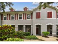 Charming townhouse exterior with red shutters, covered porch, and landscaped front yard at 9420 Georgian Park Ln # 106, Tampa, FL 33626