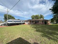 Charming single-story home with a well-manicured lawn and a convenient RV parking space at 10458 Clingman St, Spring Hill, FL 34608