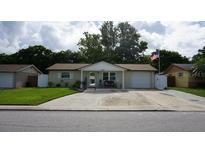Charming single-story home featuring a well-manicured lawn, a long driveway and a cozy front porch at 11810 Oceanside Dr, Port Richey, FL 34668