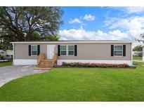 Charming single-story home with a well-maintained lawn, inviting entryway, and pleasing landscaping at 16104 Naples St, Brooksville, FL 34604