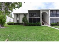 Well-maintained two-story condo featuring lush landscaping and screened in lanai at 3153 Lake Pine Way # A1, Tarpon Springs, FL 34688