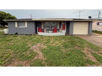 Charming single-story home with a cozy front yard and inviting front patio seating area at 5208 Chet Dr, New Port Richey, FL 34652