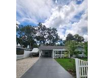Charming single Gathering home featuring a driveway, carport, well-manicured lawn and picket fence at 5710 Broadway Ave, New Port Richey, FL 34652