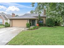 Charming single-story home featuring a well-maintained lawn, a two-car garage, and traditional architectural details at 7230 Hummingbird Ln, New Port Richey, FL 34655